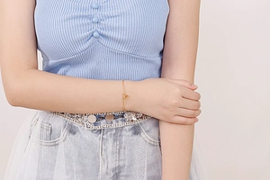 Close-up of a minimalist gold bracelet featuring a modern V-shaped pendant on a fine chain