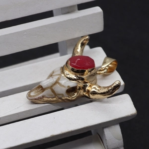 Natural stone bull head pendant with gold horns and red gemstone on a mini chair
