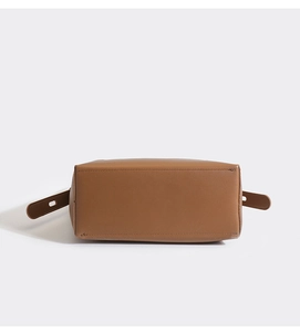 Detailed bottom view of brown leather bucket bag showing fine texture and neat stitching