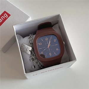 Macro view of blue square quartz watch with brown silicone strap in a gift box