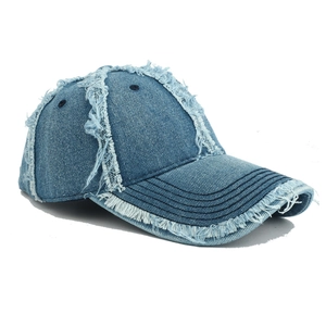 Distressed washed denim baseball cap with vintage frayed edges and torn holes for street style