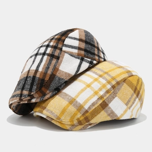Detailed view of vintage plaid newsboy caps in brown and yellow checked patterns