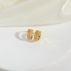 Close-up of gold heart-shaped hoop earrings with diamond accents on white pedestal