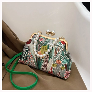 Detail einer Vintage Brokat-Handtasche mit übergroßem Perlenkoffergriff und Goldverschluss