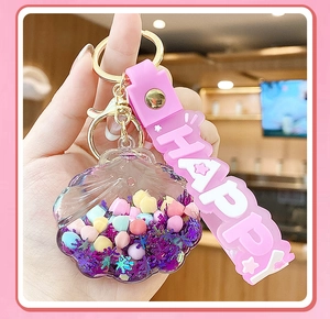 Close-up of pink shell keychain with colorful beads and Happy silicone strap