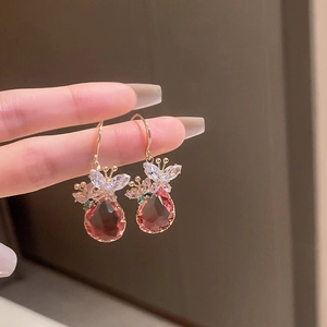 Détail de boucles d'oreilles papillon en zircon avec gouttes d'eau rouge-brun