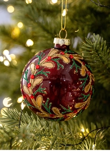 Macro detail of red Christmas glass ball with gold glitter and red faux diamonds