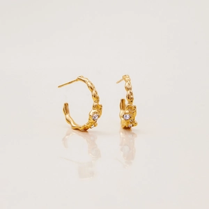 Detail of 18K gold C-shaped earrings with molten texture and inlaid clear zircons