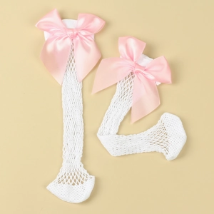 Macro shot of white mesh knee high socks featuring large pink satin bows on cuffs