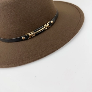 Detailed close-up of dark brown wool felt hat with black leather band and gold metal buckle