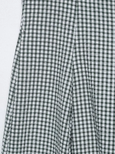 Détail macro du tissu seersucker à carreaux vert et blanc pour une robe midi chic