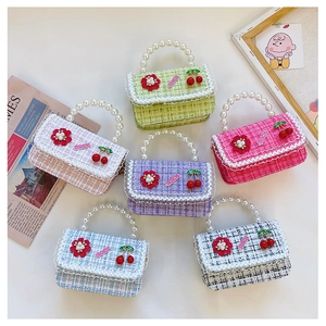 Detail of colorful tweed handbags with pearl handles and decorative floral patches