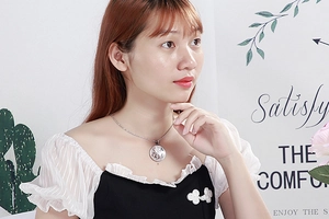 Modern model wearing a vintage round stainless steel pendant necklace on silver chain