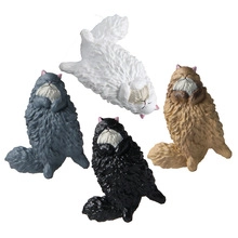 Close-up of four miniature longhair cat figurines in grey white black and tan colors