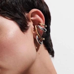 Close-up of stylish gold and silver non-piercing ear cuffs layered on ear