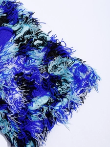 Detailed macro view of the fluffy blue and black mixed knit yarn texture of the balaclava