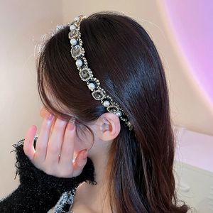 Detail of elegant headband featuring alternating pearls and grey crystals on gold base
