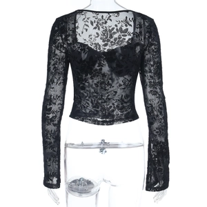 Détail du haut noir à manches longues en dentelle avec broderie florale et col en V