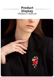 Detailed view of snake and red rose brooch with green gemstone eyes on black suit lapel