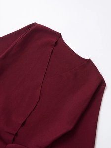 Detail of burgundy knit cardigan featuring V-neck wrap design and fine texture