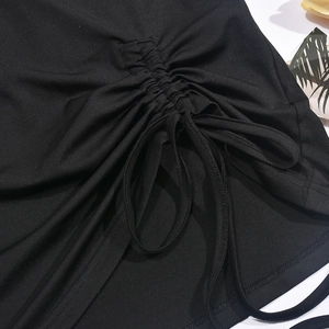 Détail d'un t-shirt noir montrant les fronces latérales et le cordon de serrage réglable