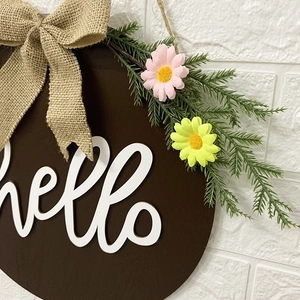 Rustic round wooden Hello sign with burlap bow and faux spring flowers for front door decor