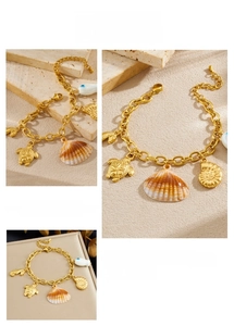 Detail of gold-plated ocean theme charm bracelet with sea turtle and shell pendants