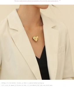 Polished gold heart pendant necklace styled with a chic beige blazer outfit