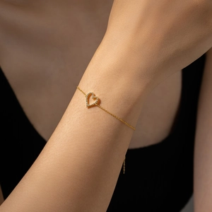 Close-up of gold heart bracelet with micro-paved cubic zirconia on a female wrist