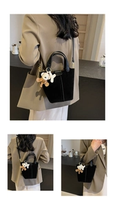 Detail der schwarzen Wildleder-Beuteltasche mit Ledergriff und 3D-Bär-Anhänger