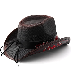Detail of red floral embroidery on black woven cowboy hat with leather band decor