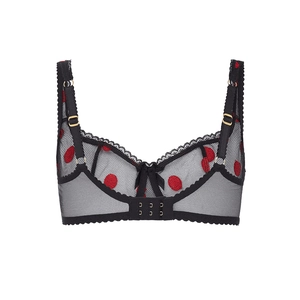 Detail of sheer black mesh bra with red polka dot embroidery and gold metal rings