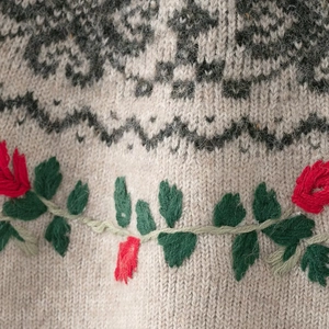 Beige knit sweater with festive Christmas floral embroidery and geometric texture detail