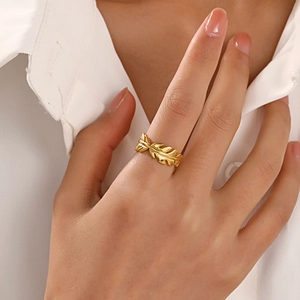 Minimalist gold leaf stainless steel ring with polished finish on model's hand