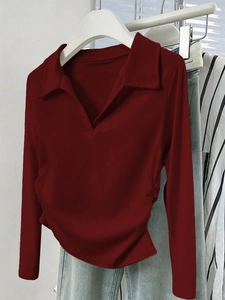 Détail de chemise rouge foncé à manches longues avec col en V sur cintre blanc