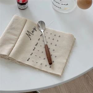 Close-up of dessert spoon with dark brown wooden handle and silver head on a May calendar