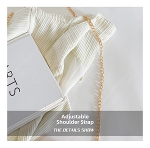 Detailed close-up of cream corduroy bag texture with golden chain strap and book prop