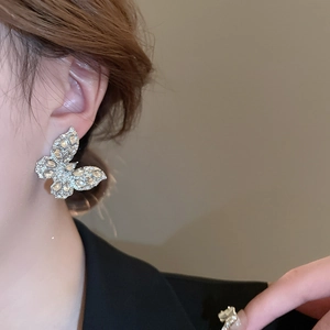 Dettaglio di un grande orecchino a farfalla in argento con strass luccicanti