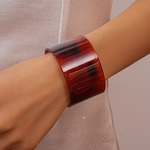 Detail shot of a wide amber tortoiseshell acetate bangle with natural marble patterns