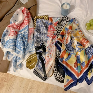 Chic multi-pattern paisley and floral silk scarves displayed in a cozy lifestyle setting