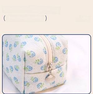 Detail display of lace makeup bag with floral print and smooth fan-shaped metal zipper
