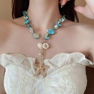 Detail of beach-style necklace set with starfish, seashell pendants and blue beads