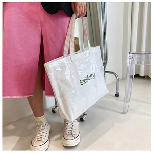 Close-up of white canvas tote with transparent PVC layer and Skillfully text detail