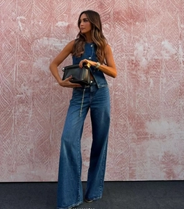Denim two-piece set featuring a sleeveless vest and wide-leg trousers with black handbag