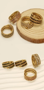 Detail of 18k gold layered ring with multi-color stones on wood and white display