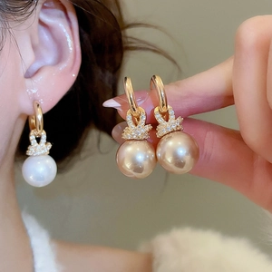 Gros plan de boucles d'oreilles perles lapin dorées avec zircons et texture premium