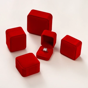 Macro shot of assorted red velvet jewelry boxes with soft texture and ring holder inserts