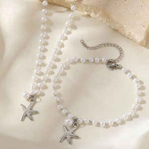 Detail of beaded necklace and bracelet with metallic starfish charms and lobster clasp