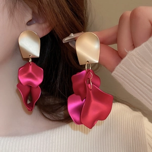 Detail of long magenta leaf tassel earrings with golden stud on a fashion model
