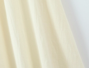 Makrodetail von cremefarbenem Kleiderstoff mit feiner seidiger Textur und Webmuster